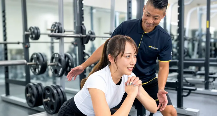 トレーナーがスクワットのフォームを個別にチェック