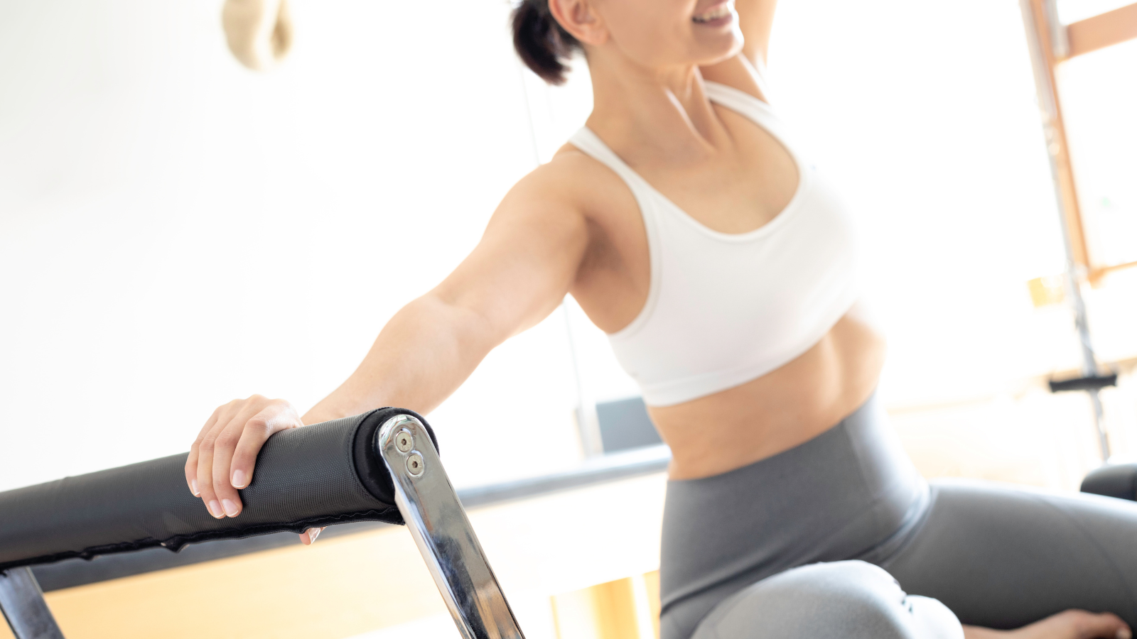 ピラティスレッスンで身体を動かす女性