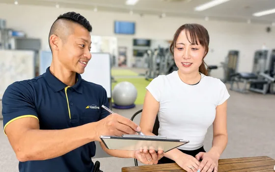 受付でヒアリングを行うスタッフと会員